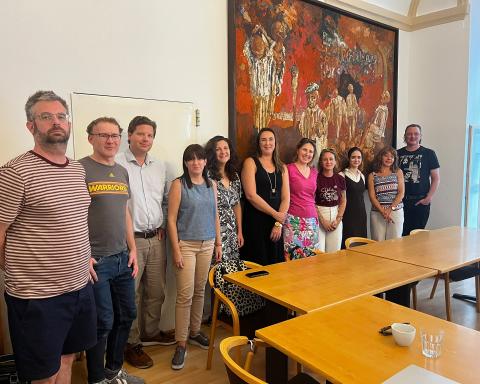 A group of people standing behind seminar tables.